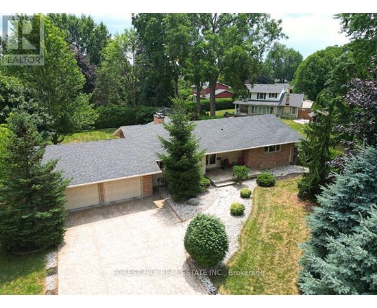 A house with a grey roof and a driveway in front of it.