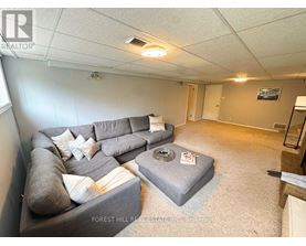 A living room with a grey couch and a grey ottoman.