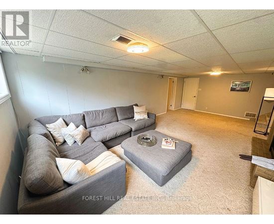 A living room with a grey couch and a grey ottoman.