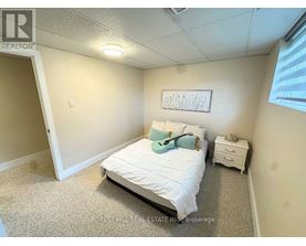 A bedroom with a bed, nightstand, and a framed picture on the wall.