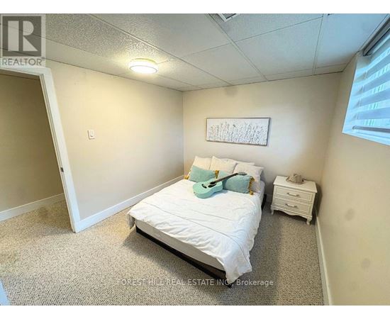 A bedroom with a bed, nightstand, and a framed picture on the wall.