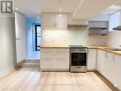 A kitchen with white cabinets and a wooden floor.