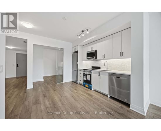A modern kitchen with white cabinets and stainless steel appliances.