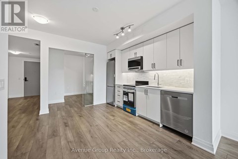 A modern kitchen with white cabinets and stainless steel appliances.