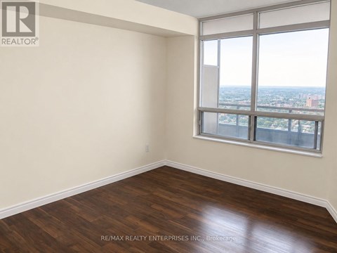 A room with a large window and wooden flooring.