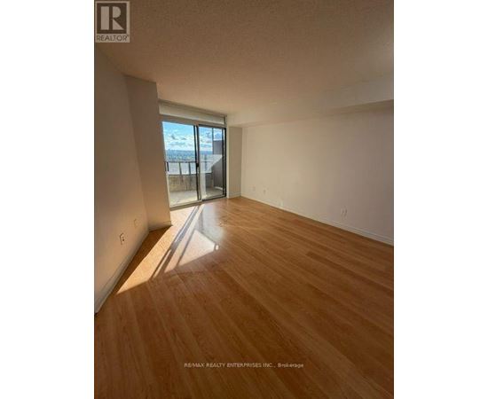 A room with wooden flooring and a large window.