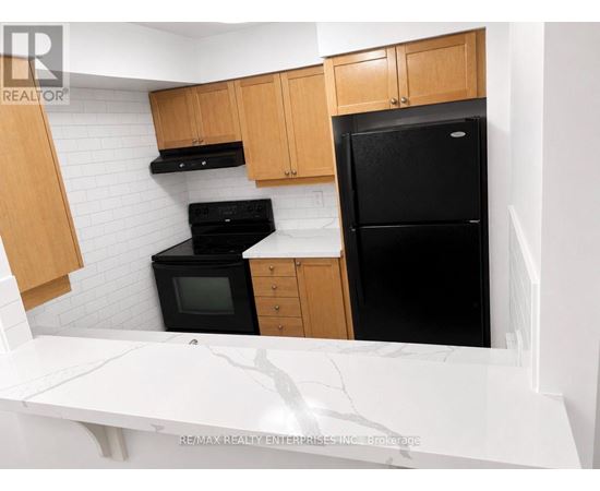 A kitchen with a black fridge, black oven, and black microwave.