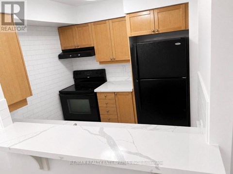 A kitchen with a black fridge, black oven, and black microwave.