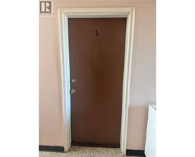 A brown door with a number 5 on it.