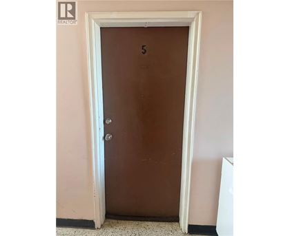 A brown door with a number 5 on it.