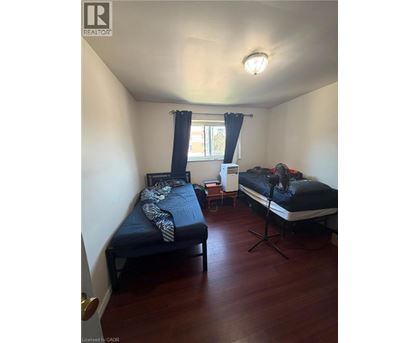 A bedroom with two beds and a window with curtains.