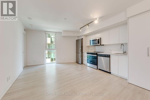 A spacious kitchen with white cabinets and stainless steel appliances.