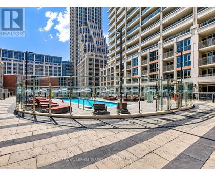 A swimming pool area with a glass enclosure and a pool table in the middle.