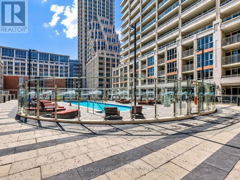 A swimming pool area with a glass enclosure and a pool table in the middle.