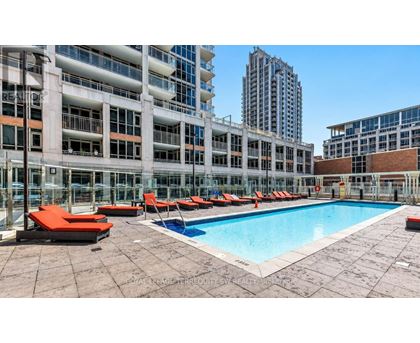 A pool area with red sun loungers and a tiled floor.
