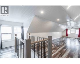 A spacious room with wooden flooring and a white ceiling.