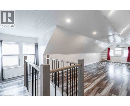 A spacious room with wooden flooring and a white ceiling.