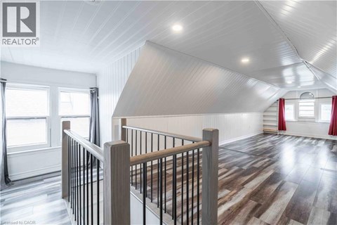 A spacious room with wooden flooring and a white ceiling.