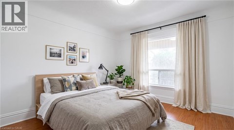 A bedroom with a large bed and a window with curtains.