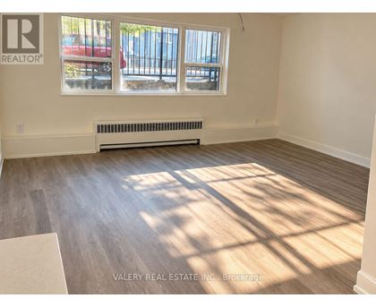 A room with a window and a radiator on the wall.