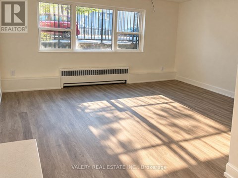A room with a window and a radiator on the wall.