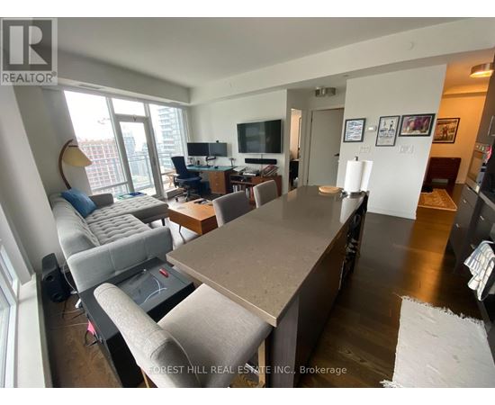 A living room with a grey couch and a brown table.