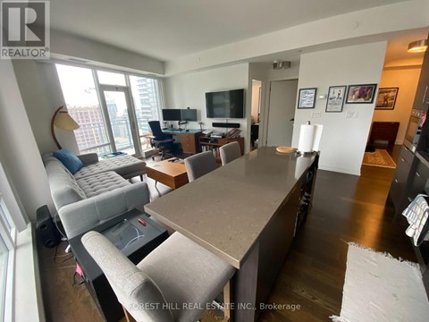 A living room with a grey couch and a brown table.