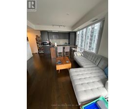 A living room with a grey couch and a wooden coffee table.