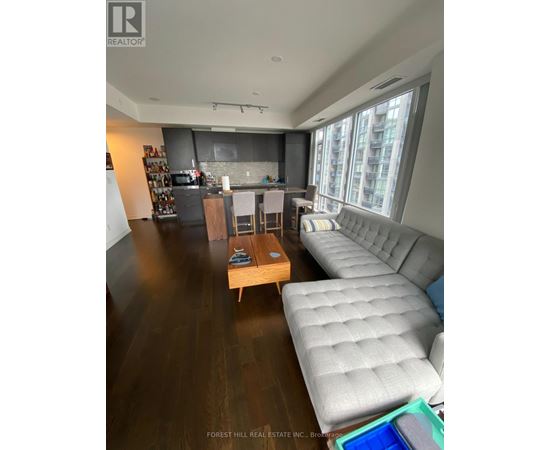 A living room with a grey couch and a wooden coffee table.