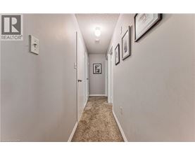 A hallway with a carpeted floor and white walls.