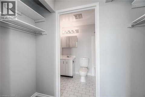 A white bathroom with a toilet, sink, and cabinet.