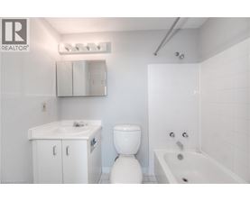 A white bathroom with a toilet, sink, and bathtub.