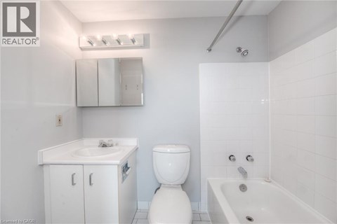 A white bathroom with a toilet, sink, and bathtub.