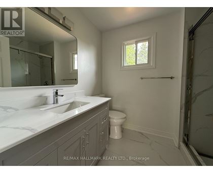 A bathroom with a sink, toilet and a window.
