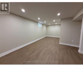 A spacious room with wooden flooring and white walls, likely a property for rent or sale.