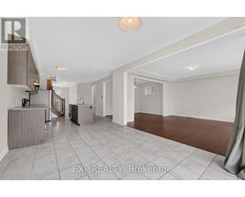 A spacious room with a staircase and a large window.