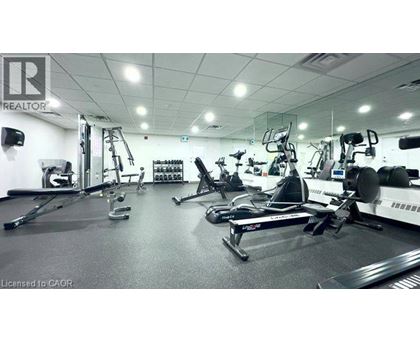 A gym with a variety of exercise equipment including treadmills, stationary bikes, and weight machines.