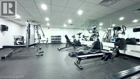 A gym with a variety of exercise equipment including treadmills, stationary bikes, and weight machines.