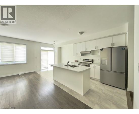 A modern kitchen with white cabinets and a central island.