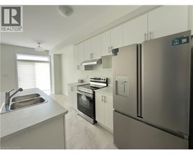 A modern kitchen with stainless steel appliances and white cabinets.