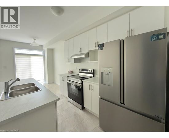 A modern kitchen with stainless steel appliances and white cabinets.