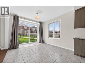 A spacious living room with a sliding glass door leading to a backyard.