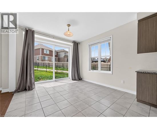 A spacious living room with a sliding glass door leading to a backyard.