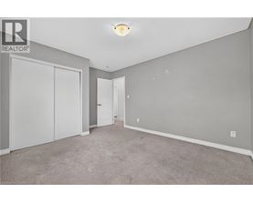 A bedroom with a carpeted floor and a white door.