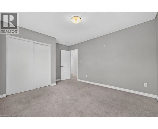 A bedroom with a carpeted floor and a white door.