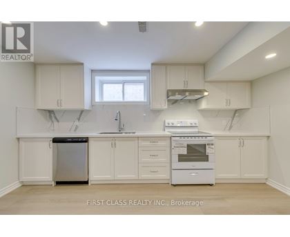 A kitchen with white cabinets and appliances, including a dishwasher and oven.