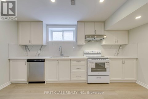 A kitchen with white cabinets and appliances, including a dishwasher and oven.