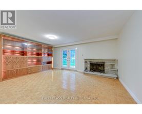 A spacious room with a fireplace and a large window.