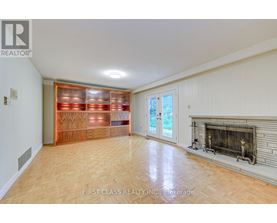 A spacious living room with a fireplace and a wine rack.