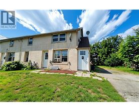 A house with a blue door and windows is for sale.